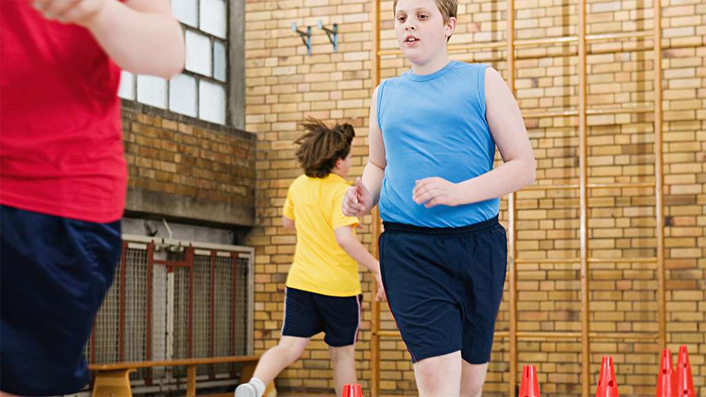 Kids running around cones in a gym