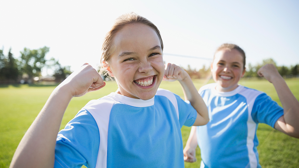 Smiling girls showing strong arms