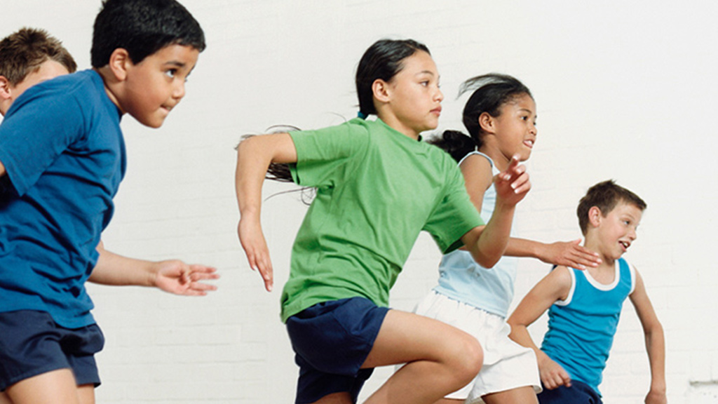 Children running to pick up bean bags for memory power game